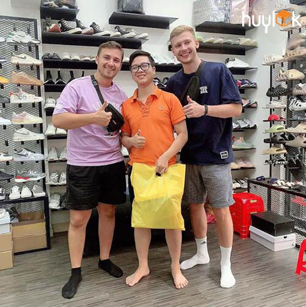 Huy Lock chụp hình với 2 khách tây tại cửa hàng giày sneaker